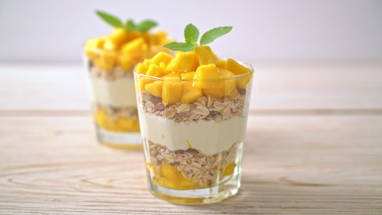 yogur de mango fresco con granola en vidrio - estilo de comida saludable