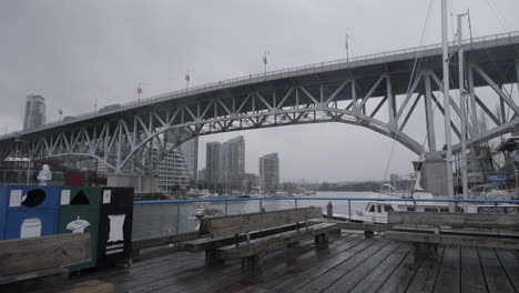 wide shot of granville island boardwalk and bridge on cloudy day