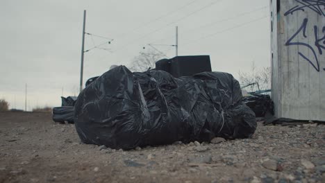 illegal dump outside, black garbage plastic bag with rubbish or dead body, crime scene