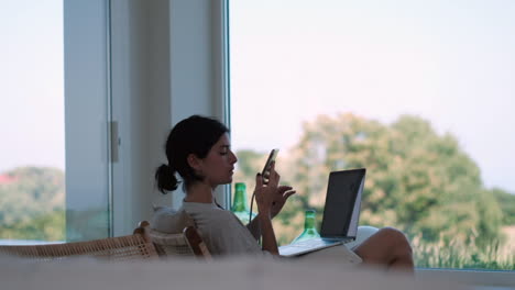 freelancer lifestyle: young woman on phone with laptop in nature