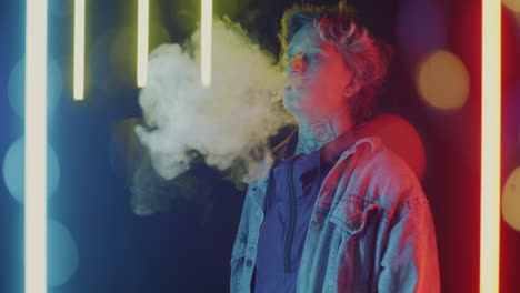 young person exhaling vapor with neon lighting