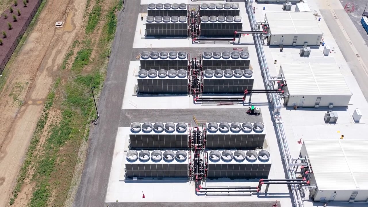 Grandi chiller raffreddati ad aria o unità dry-cooler a supporto dell'infrastruttura di raffreddamento di un data center. Fila di scambiatori di calore a ventilazione forzata, vista aerea.