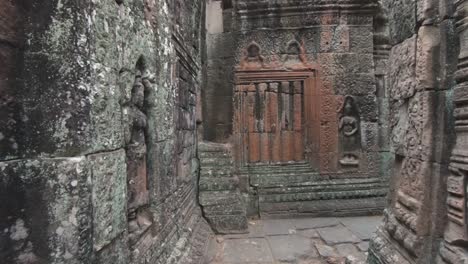 visitor walking point of view of angkor temple carved walls details