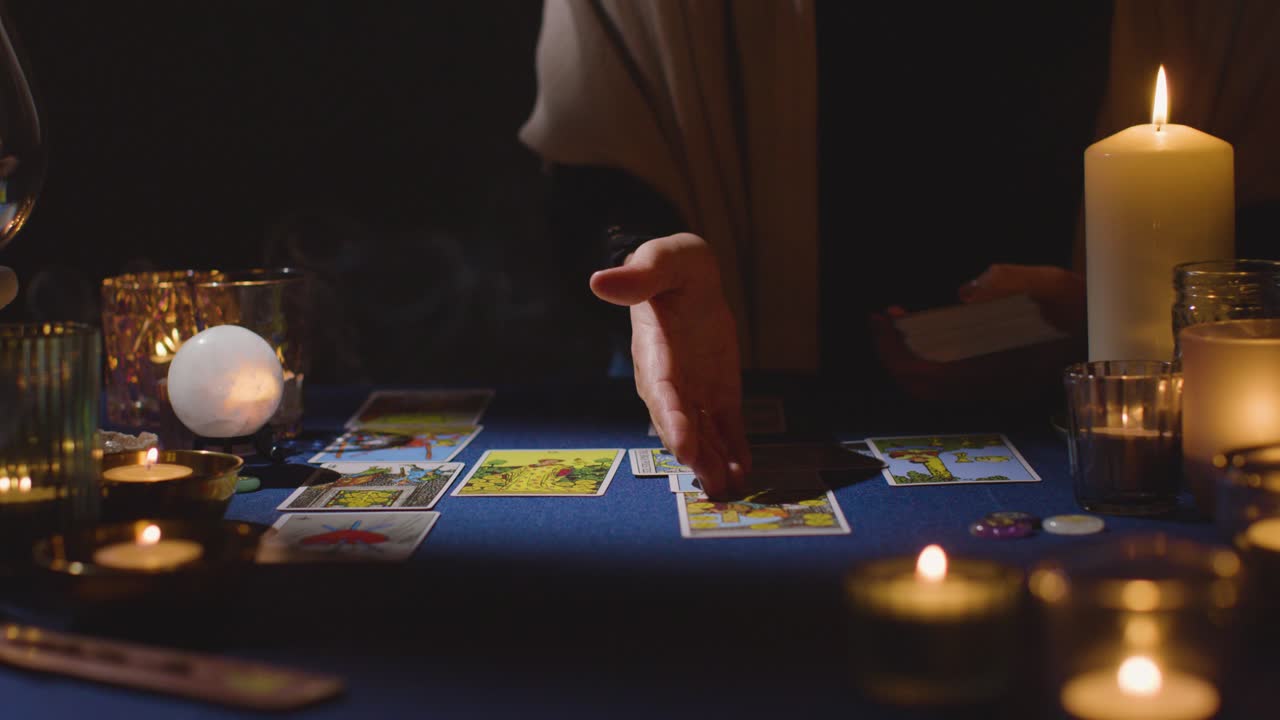 un primer plano de una mujer dando una lectura de cartas del tarot en la mesa 11 a la luz de las velas.