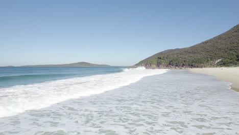 foamy waves rolling in the shore of zenith beach in shoal bay, australia