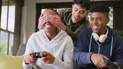 happy diverse male teenage friends playing video games at home, slow motion