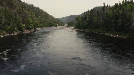 aerial view of a serene river flowing through a lush forest