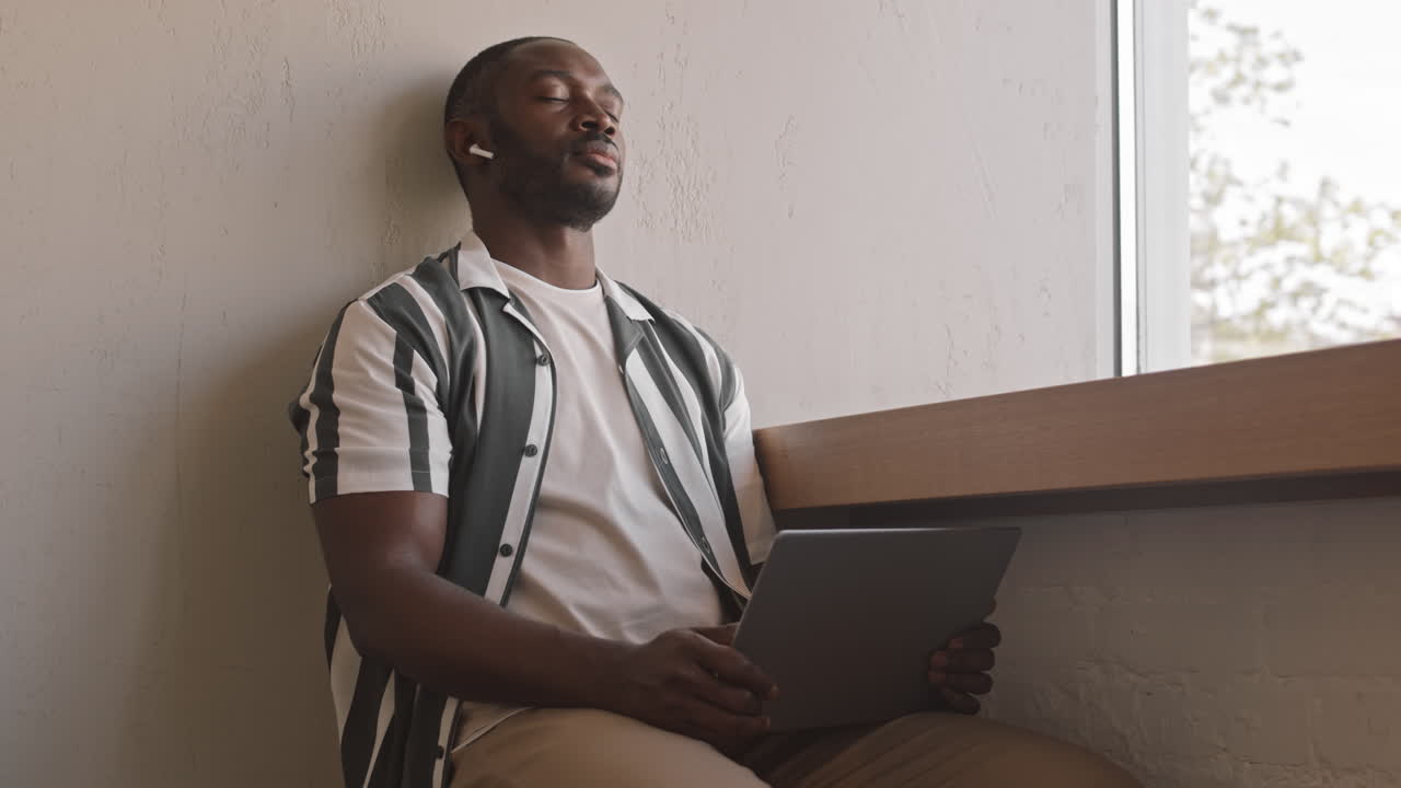 Afro American Man Enjoying Music in Earbuds