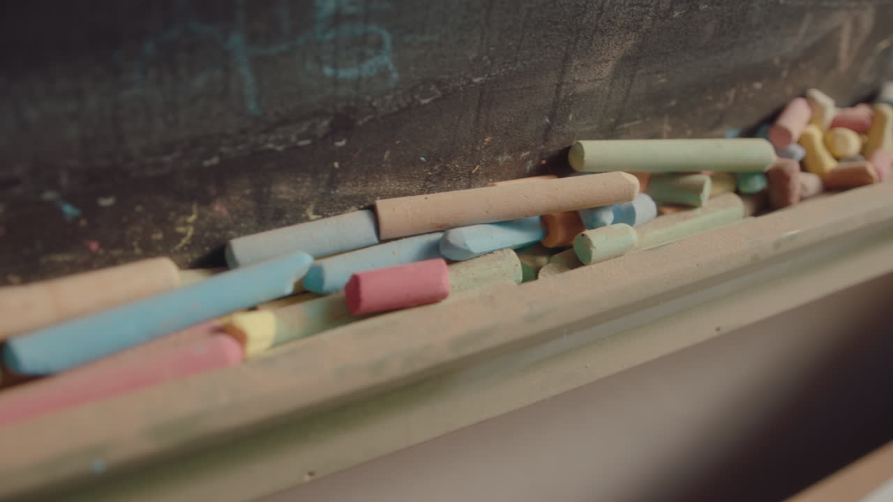 Colorful Chalk Sticks in front of Blackboard