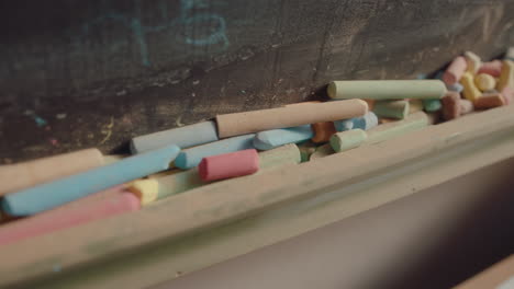 colorful chalk sticks in front of blackboard