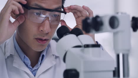 scientist uses a microscope