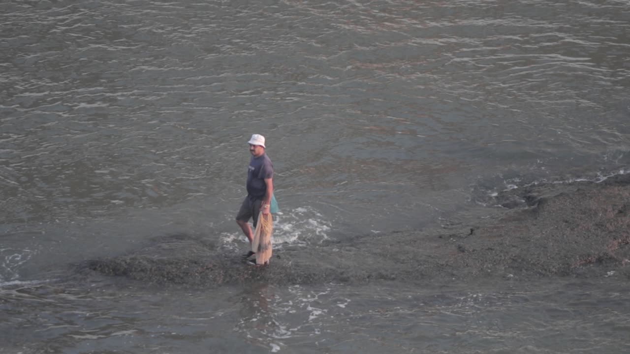 pescador indio local recogiendo su red de pesca