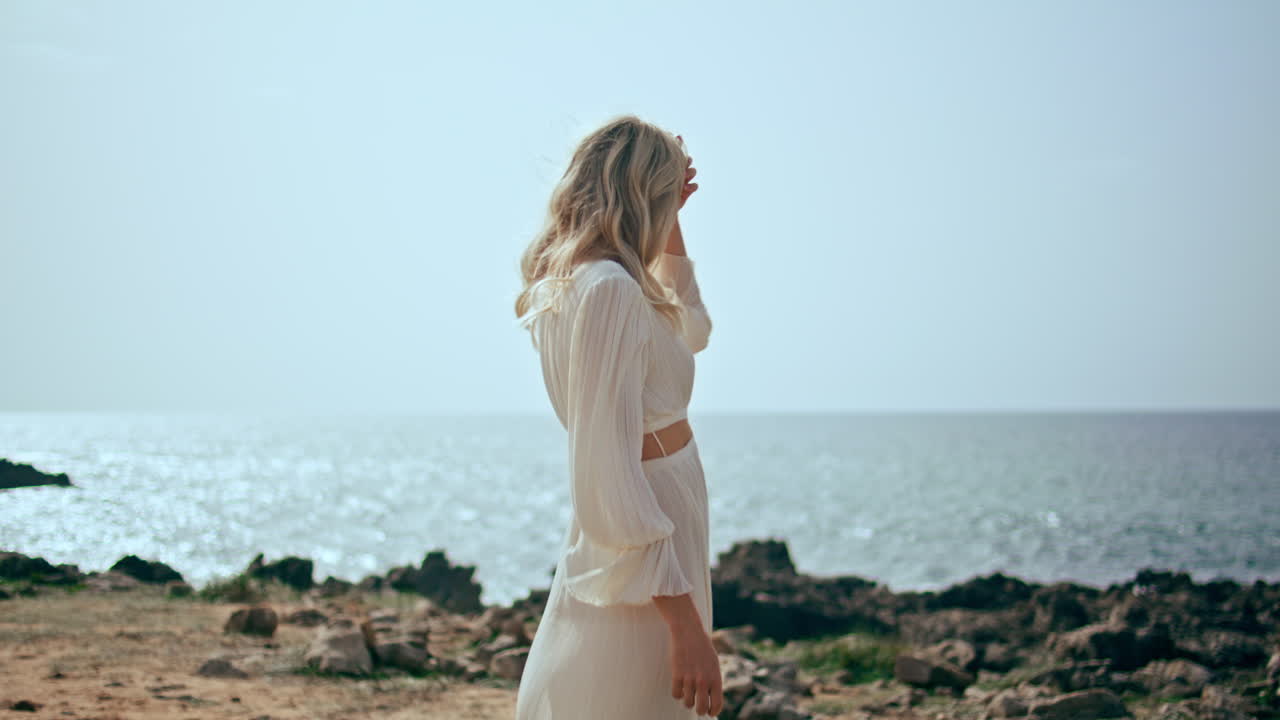 아름다운 해가 지는 빛에 부드러운 여자가 휴식을 취하는 해안. 바가에서 걸어가는 소녀