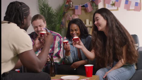 mujer en casa sirviendo pasteles con estrellas y rayas americanas en miniatura banderas a amigos en una fiesta que celebra el 4 de julio día de la independencia 5
