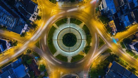 aerial night view of a busy urban roundabout with light trails