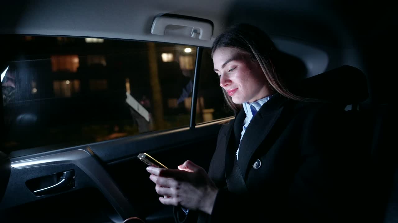 Woman using smartphone in taxi at night