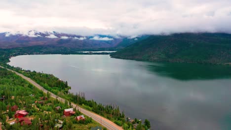 Vista-Aérea-Por-Drones-Del-Hermoso-Gran-Lago-Y-El-Embalse-De-La-Montaña-En-La-Sombra-En-Un-Día-Nublado-De-Verano-Con-Autos-Conduciendo-Por-La-Carretera-De-Colorado-A-Lo-Largo-De-La-Costa-Nublada