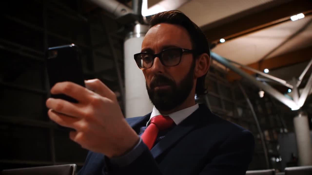 pasajero que usa teléfono móvil en el área de espera 4k