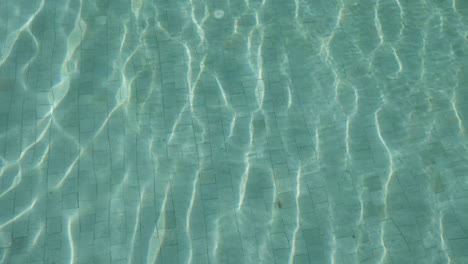 view of the surface of the water in swimming pool with sunlight reflected on the surface