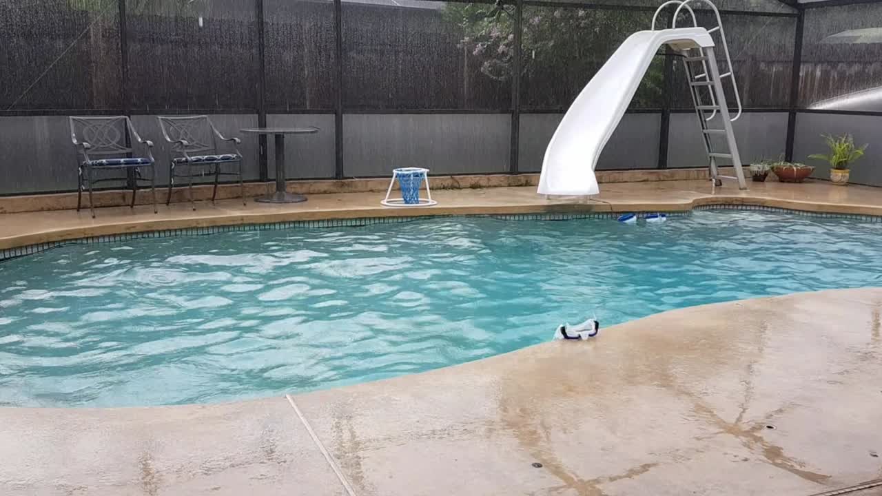 hermosa piscina azul cerrada en el patio trasero con tobogán bajo la lluvia, florida central