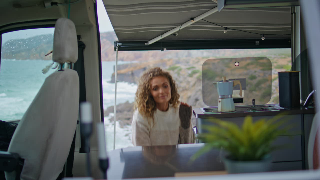 Happy traveller entering camper van at carefree autumn weekend. Woman relaxing