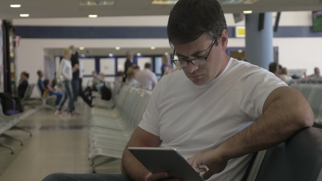 hombre pasando el tiempo antes de la salida con la tableta