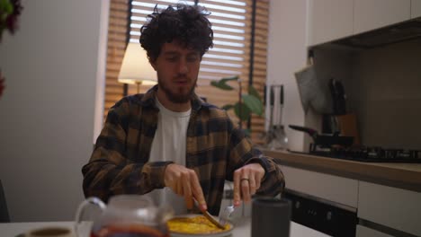 hombre comiendo desayuno en una cocina moderna