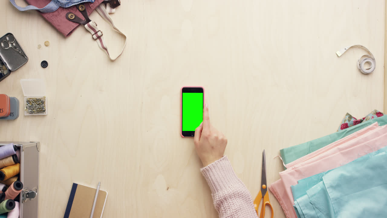 vista superior de las manos del diseñador de moda usando una aplicación de diseño de teléfono móvil trabajando en el escritorio desde arriba - dragón épico rojo