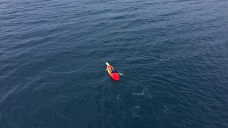 guy paddling kayak on blue sea during summer vacation near san pablo island in leyte, philippines