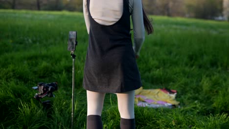 young woman recording video in a park