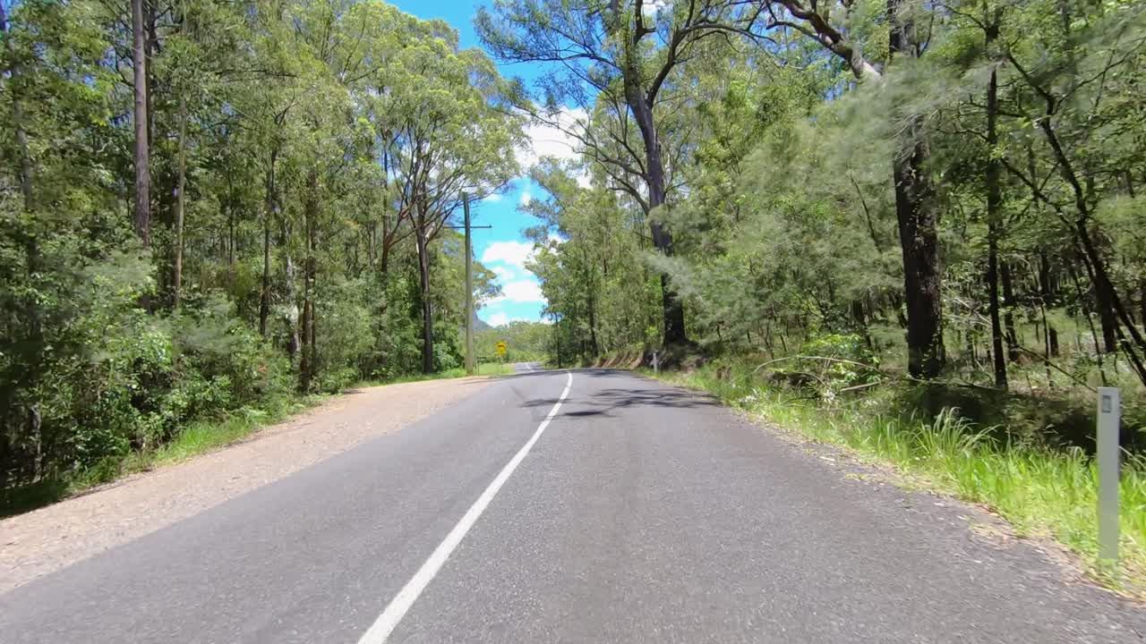 쿠노우린 산이 멀리 보이는 황량한 퀸즐랜드 시골길의 후면을 향한 운전 관점 - 실내 자동차 장면 그린 스크린 교체에 이상적