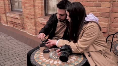 una pareja de turistas caucásicos sentados en una cafetería al aire libre.