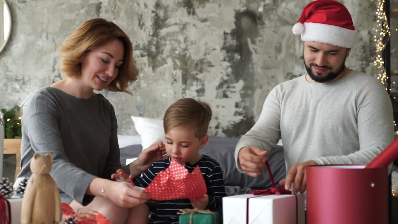 madre, padre e hijo pequeño preparan regalos de navidad 1