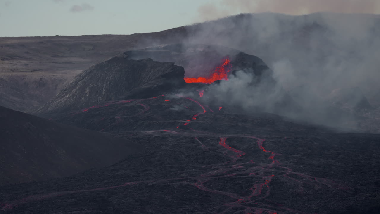 Lava Flows And Smoke From The Crater Of Fagradalsfjall Volcano During Eruption In Iceland At Sunset