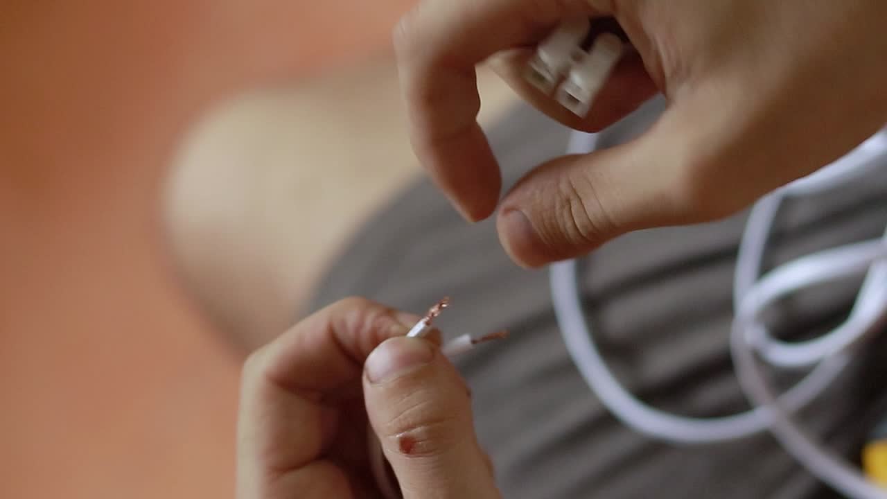 primer plano de las manos de un electricista que intenta conectar un cable eléctrico a un conector de cable de bloqueo automático