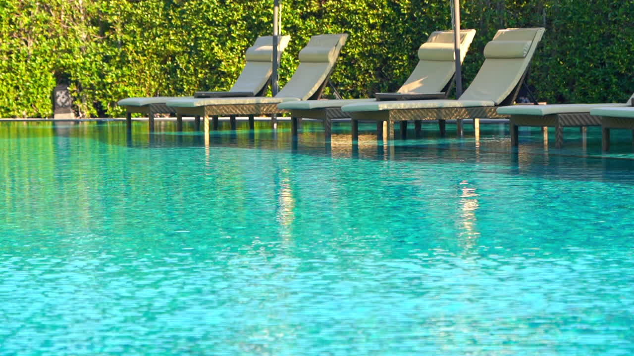 Luksushotels liggestole ved den blå swimmingpool
