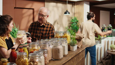 o vendedor ajuda um velho cliente na loja de alimentos.