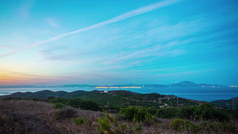 timelapse of streaked sunset skies over rolling hills and distant coastline on a beautiful day