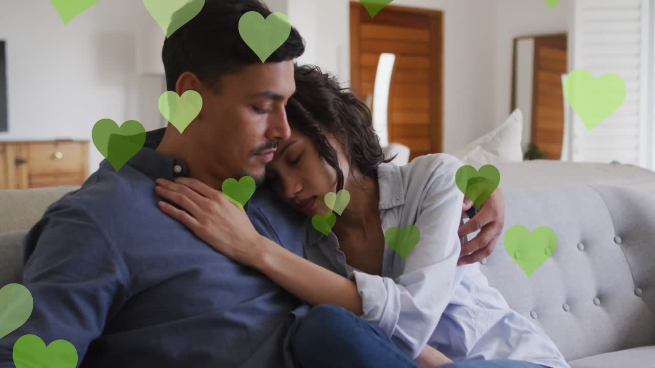 두 인종의 커플이  ⁇ 안고 있는 하트 아이콘의 애니메이션