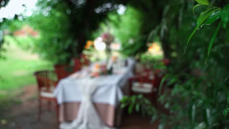 Empujando-El-Foco-A-La-Mesa-De-Bodas-Decorada-Con-Flores,-Candelabros-Para-Parejas-Y-Padres-En-Un-Jardín-Al-Aire-Libre