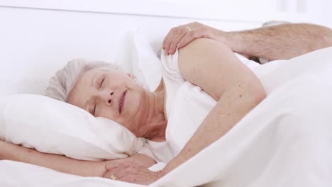Senior-woman-sleeping-on-bed