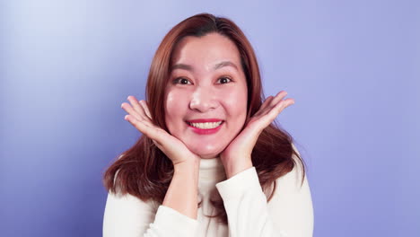 긍정적인 표정을 가진 젊은 아시아 여성의 초상화, 즐거운 깜짝 펑키, 보라색 배경-1을 통해 카메라를 바라보고 있습니다.
