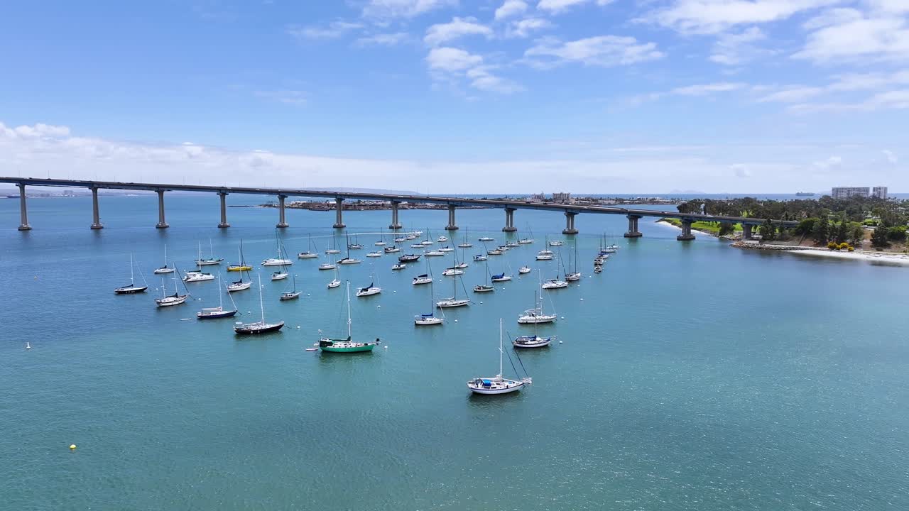 Aerial Descending view of Sailboats mooring around Coronado Bridge San Diego