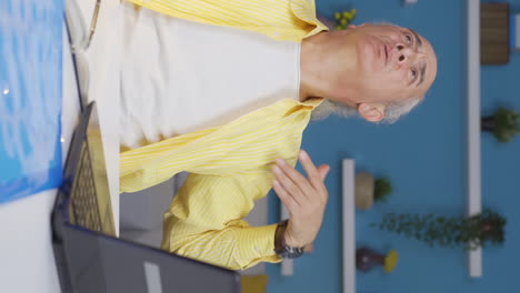 Vertical-video-of-Home-office-worker-old-man-is-suffocating-from-hot-weather.