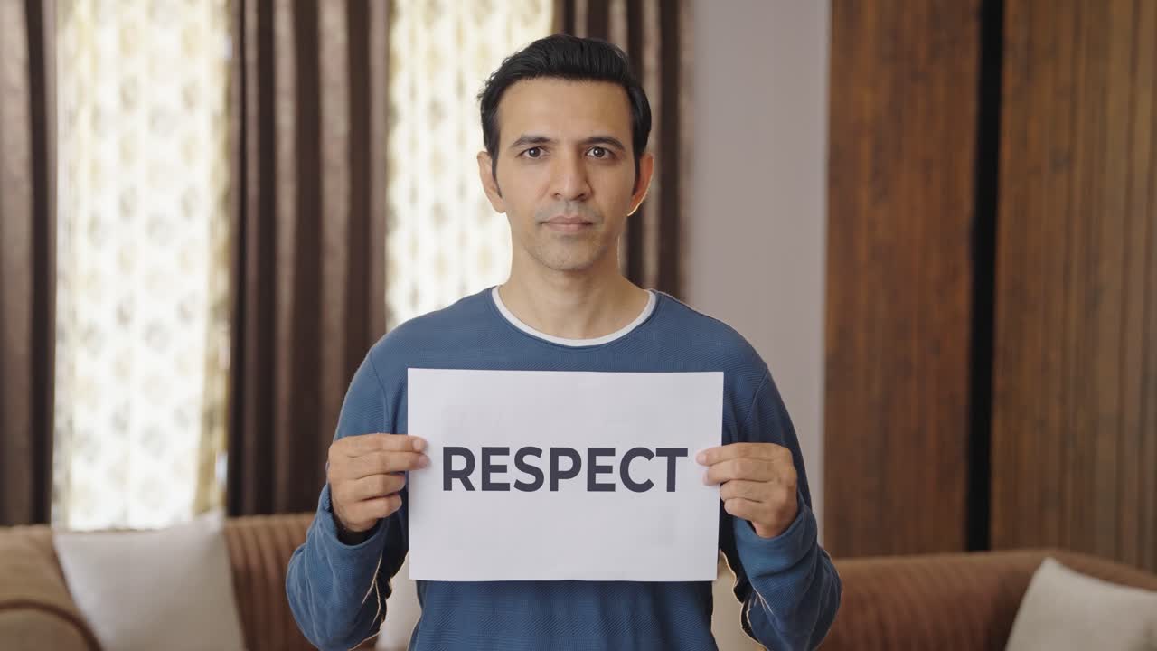 Indian man holding RESPECT banner
