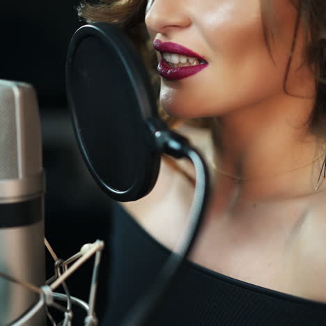 young girl singing into a microphone in a studio. close-up of a singer. square video