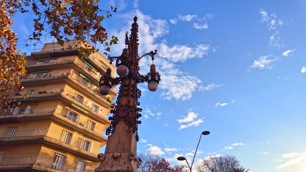 Apresentação orbital de um poste de iluminação histórico de três lâmpadas em Barcelona mostra a coluna de pedra ornamentada, os braços de metal decorativos e o difusor esférico, Comunidade Autônoma da Catalunha, Espanha