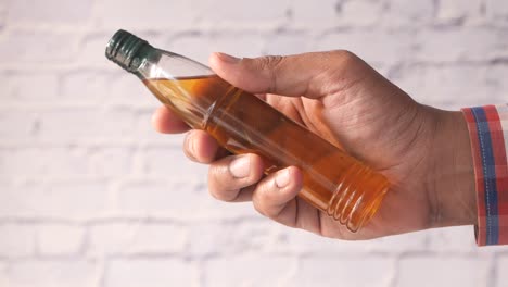 hand holding a small bottle of oil