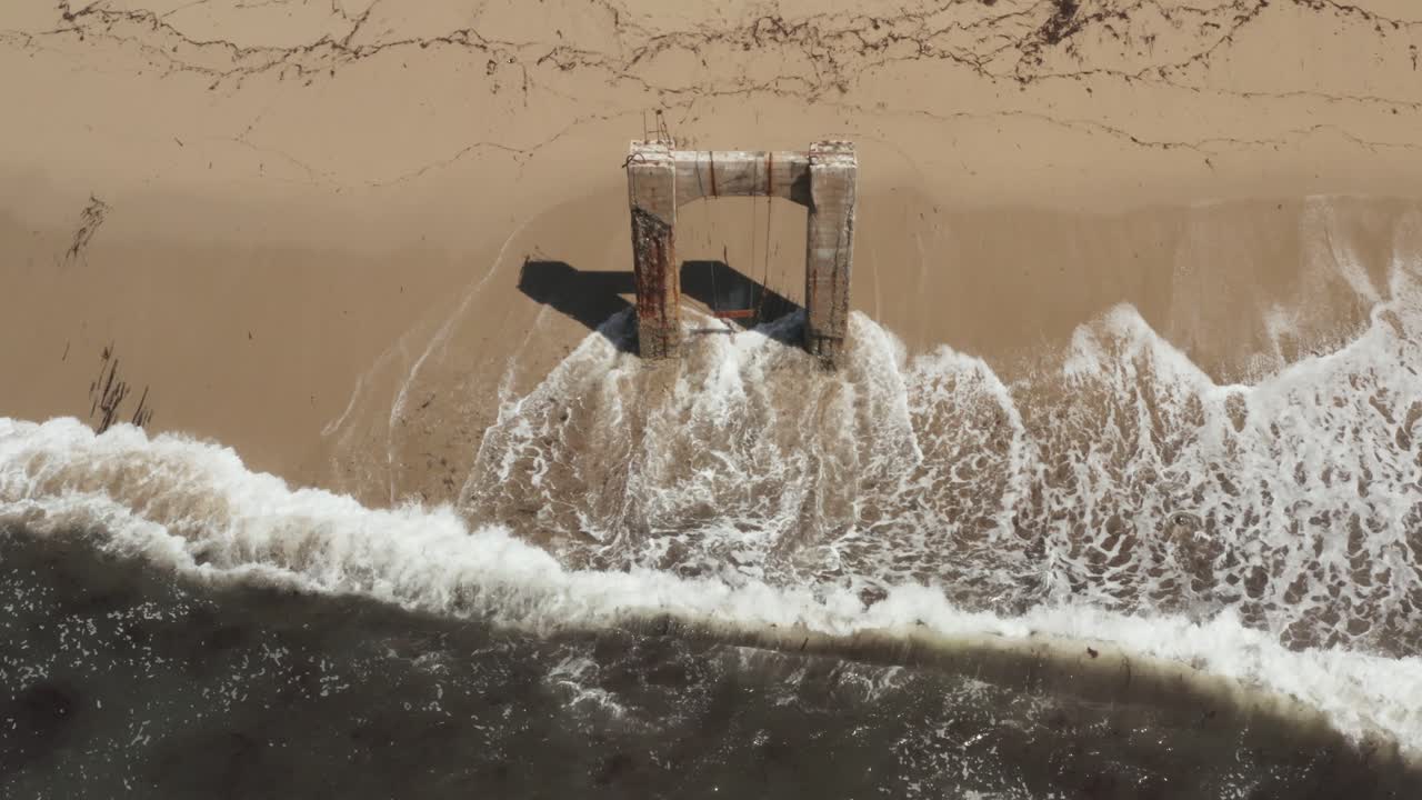 Aerial View of old broken pier made of cement in the middle of the ocean near Santa Cruz California