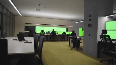 empty office, desk, and chairs at a main cctv security data center with green screen and chroma key